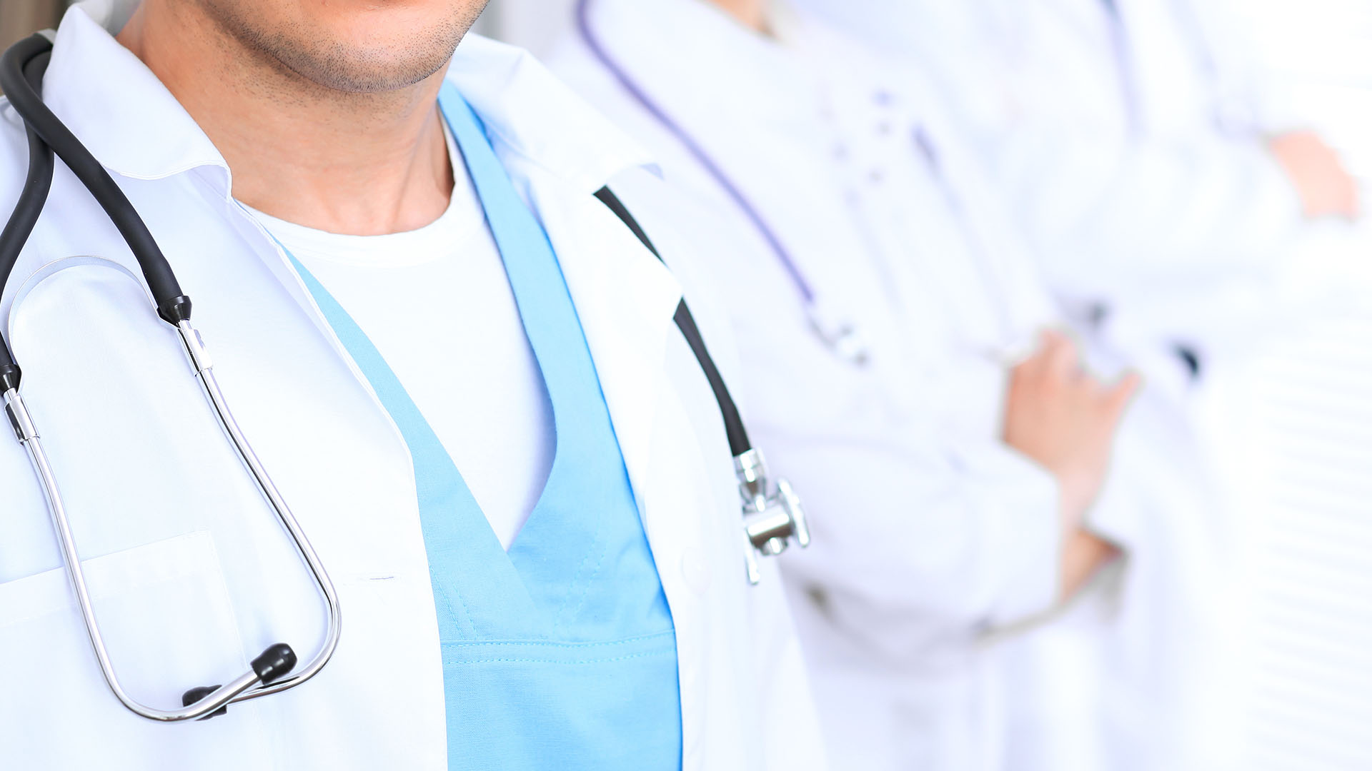 Groupe of unknown doctors standing straight in hospital office. Close Up of stethoscope at practitioner breast